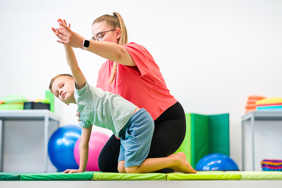 Boy doing physical therapy with instructor- occupational therapy
