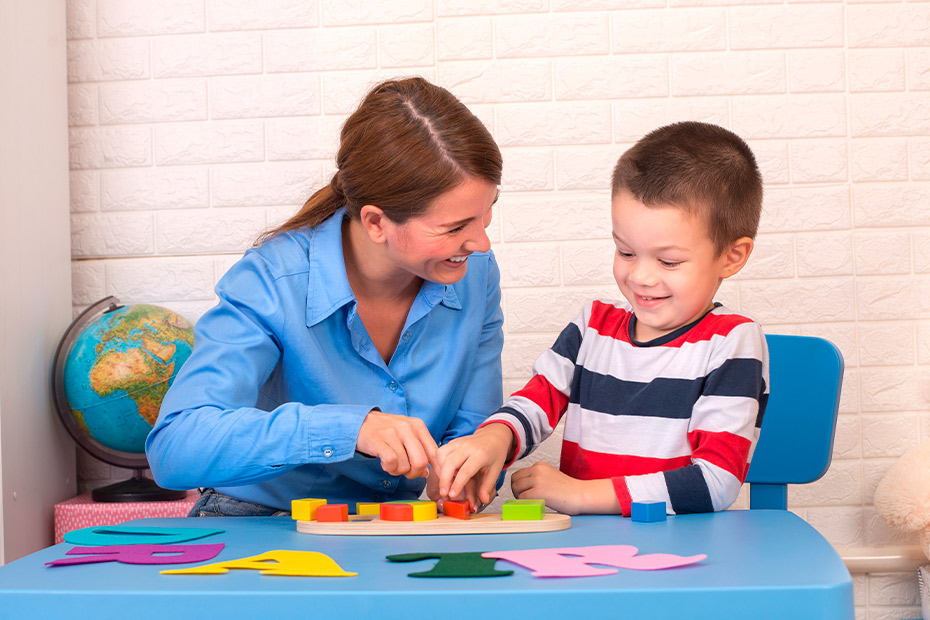 boy and woman playing with board game. Having fun. Occupational therapy