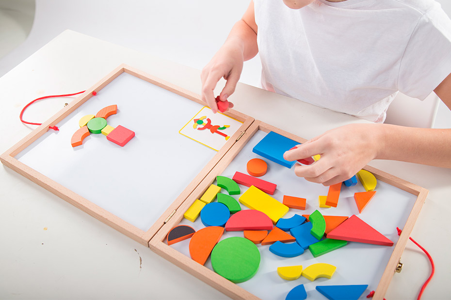 A child engaged with a colorful wooden puzzle board, enhancing cognitive skills through play in an occupational therapy setting.