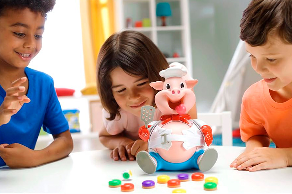 Three kids happily interacting with a pig toy, participating in playful speech therapy activities.