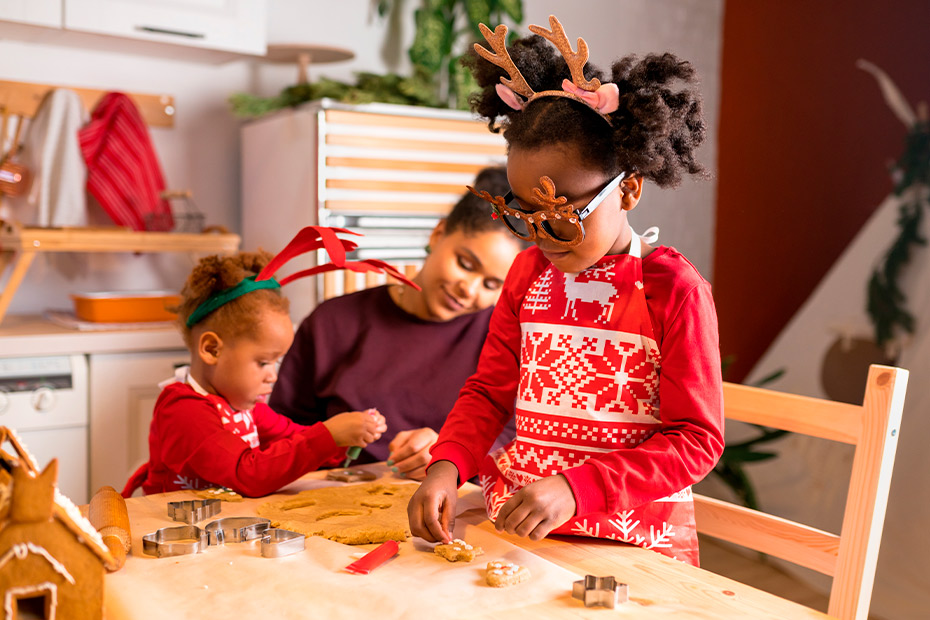 Three children, including a young girl, dressed in Christmas outfits, participate in fun activities to develop motor skills.