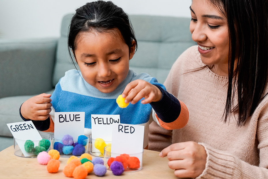  A woman and child interactively playing with vibrant balls, highlighting playful moments that support child development.