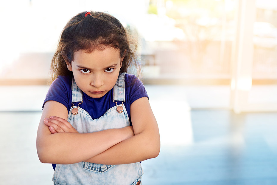 A young girl stands with her arms crossed, conveying a sense of contemplation related to speech therapy in McAllen, TX.