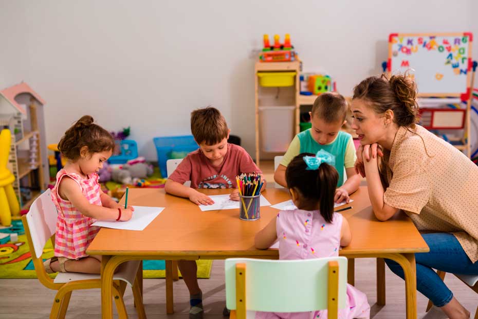 Children in the daycare are drawing on the table
