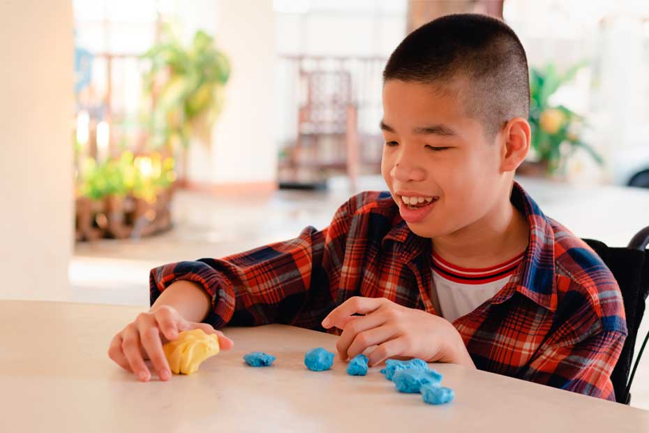 Asian disabled child on wheelchair molding clay, Fun and entertaining activity for training small and large muscles, Lifestyle in the education age of special need kids, Happy disability kid concept.